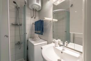 W łazience znajduje się umywalka, toaleta i lustro. w obiekcie Vito apartment w Splicie