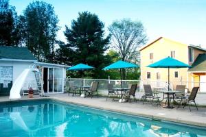 a pool with tables and chairs and a water slide at Motel de la montagne Orford in Orford