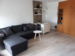 a living room with a black couch and a table at Appartement Altreichenau in Neureichenau