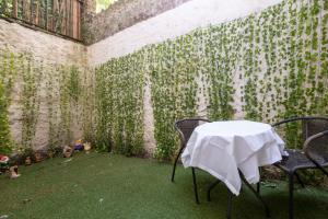 a table and chairs in a room with a wall covered in ivy at Brunswick in Brighton and Hove by 9S Living in Brighton & Hove