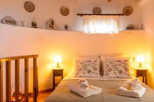 a bedroom with a bed with two towels and two lamps at Traditional Windmill-Milos in Kroústas