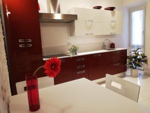 uma cozinha com uma flor vermelha num vaso vermelho sobre uma mesa em Althamer Palace Apartments em Arco