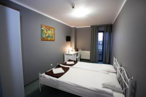 a bedroom with a white bed and a window at Hotel Kreator-Sport in Kraków