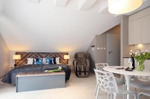 - une chambre avec un lit, une table et des chaises dans l'établissement Apartamenty Biała Sowa Czarna Góra, à Sienna