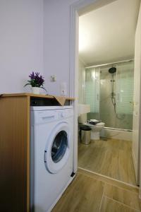uma máquina de lavar roupa branca na casa de banho com WC em Fergani Apartments em Moúdhros