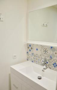a bathroom with a white sink and a mirror at Mon petit chez moi in Chinon