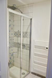 a shower with a glass door in a bathroom at Mon petit chez moi in Chinon