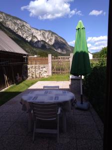 a table and a green umbrella in a yard at Casetta Alex Desiree in Pontebba +4 photos