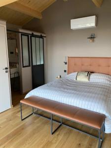 Schlafzimmer mit einem Bett mit einer Bank in der Unterkunft Les Barras’k in Saint-Péray