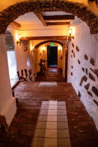 an alley way in a building with a stone wall at Casa Baroca in Sighişoara