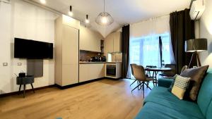a living room with a blue couch and a kitchen at Marmot apartment up & down in Poiana Brasov +13 photos