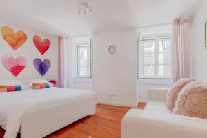 ein weißes Schlafzimmer mit Herzen an der Wand in der Unterkunft InLoveApartments - One Love, One Heart in Lissabon