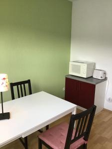a kitchen with a white table and a microwave at Haus Rheinsteig in Unkel