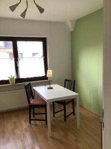 a white table and chairs in a room with a window at Haus Rheinsteig in Unkel