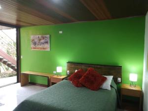 
a bed in a bedroom with a green wall at La Guayaba Monteverde in Monteverde Costa Rica
