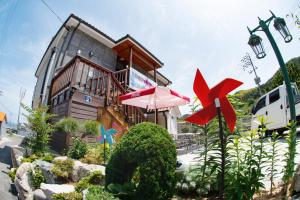 una casa con un ombrello davanti di Geoje Blueberry Pension a Geoje