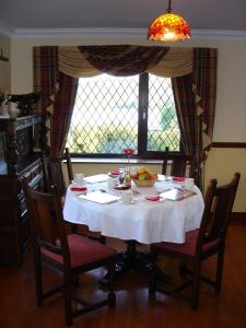 una mesa con mantel blanco y un tazón de fruta en AbbeyCourt Kenmare Kerry, en Kenmare