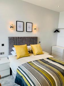 1 dormitorio con 1 cama grande con almohadas amarillas en The Marlborough Sea View Holiday Apartments en Scarborough