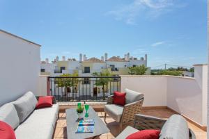 a living room with a couch and chairs on a balcony at Casa Joana at Opomar by Cara Rentals in Cabanas de Tavira