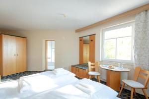 1 Schlafzimmer mit 2 Betten, einem Tisch und Stühlen in der Unterkunft Stiefelburg Der Berghof in Nauendorf