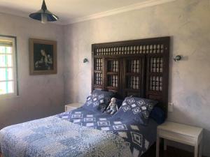 a bedroom with a bed with a wooden headboard at Mas de la Croix in Saint-Christol-lès-Alès