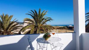 a table on a balcony with a view of the beach at Hotel Avenida Playa in Zahara de los Atunes