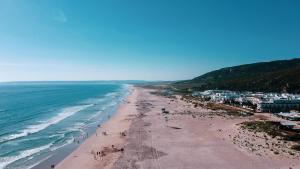 a view of a beach with the ocean and buildings at Hotel Avenida Playa in Zahara de los Atunes