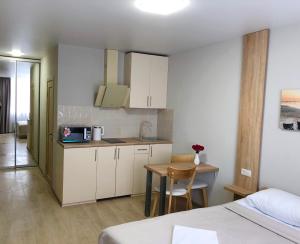 a room with a bed and a kitchen with a table at East Residence Gray in Kyiv