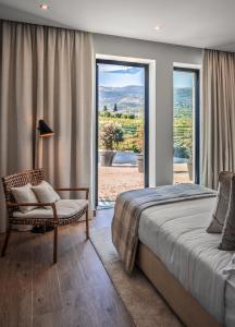 um quarto com uma cama, uma cadeira e uma janela em Quinta da Salada - Turismo Rural em Lamego