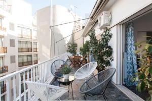 雅典的住宿－A Masterpiece in Plaka with Big Balcony and Acropolis View，公寓的阳台配有桌椅和植物