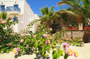 uma casa com flores em frente em Manos Apartments em Megas Gialos - Nites