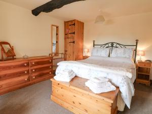 AlderwasleyにあるWigwell Barnのベッドルーム1室(ベッド1台、木製テーブルのタオル付)