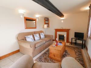 a living room with a couch and a tv at Wigwell Barn in Alderwasley