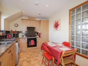 a kitchen with a table with a red table cloth at Riverview Apartment in Inverness