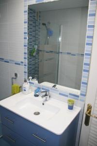 Un baño con un lavabo blanco y un espejo. en Costa del Sol, Puerto de la Duquesa, en Castillo de Sabinillas