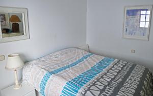 Dormitorio blanco con cama y lámpara en Costa del Sol, Puerto de la Duquesa, en Castillo de Sabinillas