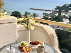 a table with a plate of fruit and a vase of flowers at Mediterraneo Sitges in Sitges
