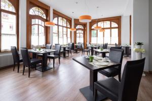 因特拉肯的住宿－隆茲博酒店，用餐室设有桌椅和窗户。