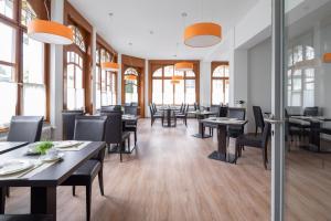 a dining room with tables and chairs and windows at Hotel Lötschberg in Interlaken +22 photos