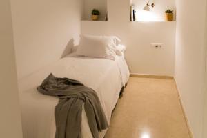 a small bedroom with a bed with a blanket on it at Mediterraneo Sitges in Sitges