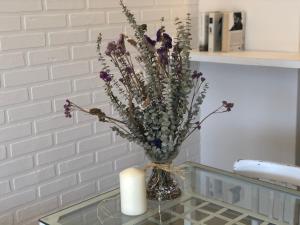 a vase with flowers and a candle on a glass table at Mediterraneo Sitges in Sitges