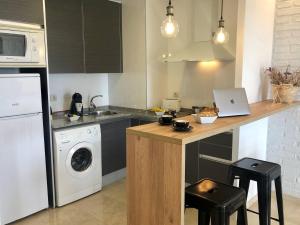 a kitchen with a counter with a washing machine at Mediterraneo Sitges in Sitges