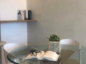 a glass table with a book and glasses on it at Mediterraneo Sitges in Sitges