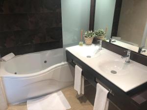 a bathroom with two sinks and a bath tub at Mediterraneo Sitges in Sitges