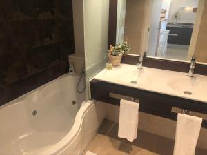 a bathroom with two sinks and a tub and a mirror at Mediterraneo Sitges in Sitges