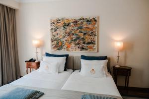 a bedroom with two beds and a painting on the wall at Challet Fonte Nova in Alcobaça