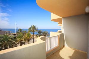 balcón con vistas a la playa y a las palmeras en Two Bedroom Apartment La Manga en La Manga del Mar Menor