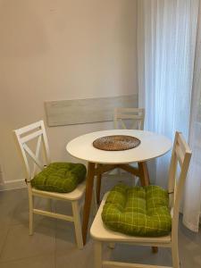 einem Esstisch mit 2 Stühlen und einem Tisch mit grünen Kissen in der Unterkunft Apartament CamInSki in Kudowa-Zdrój
