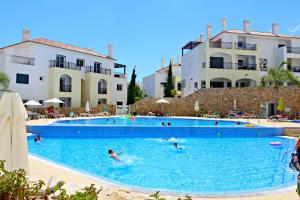 a group of people swimming in a swimming pool at Casa Joana at Opomar by Cara Rentals in Cabanas de Tavira