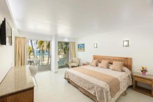 een grote slaapkamer met een bed en een balkon bij Posada Real Ixtapa in Ixtapa